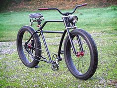 a black bicycle parked on top of a lush green field