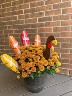 a potted plant filled with yellow flowers and paper turkeys