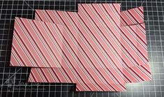 an origami cut out of paper with red and white stripes