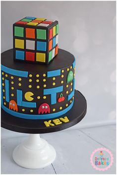 a birthday cake decorated with rubik cubes and pac - man faces on it