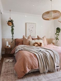 a bedroom with pink bedding and hanging plants