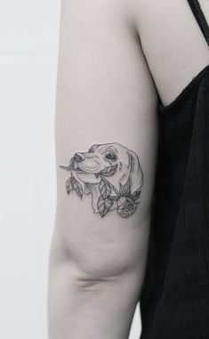 a woman's arm with a tattoo on it that has a dog and flowers on it