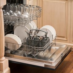 an open dishwasher in a kitchen with white dishes and silver utensils