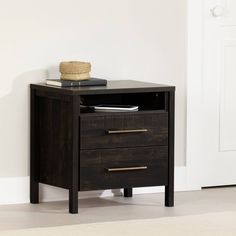 a black night stand with two drawers in front of a white door and a rug on the floor