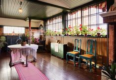 a room filled with lots of potted plants on top of wooden tables and chairs