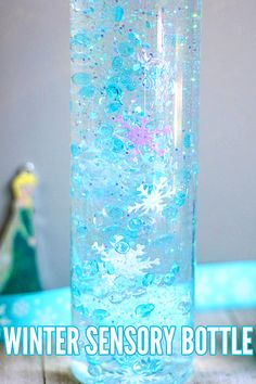 a glass filled with water sitting on top of a wooden table next to a snowman