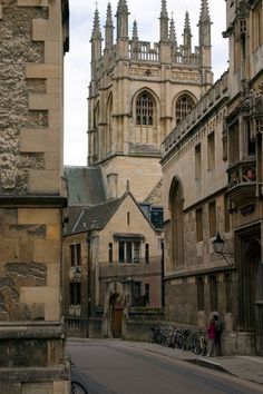 an old city street with tall buildings on both sides and bicycles parked along the side