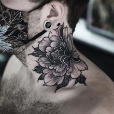 a man's neck with a black and white flower tattoo on his left side