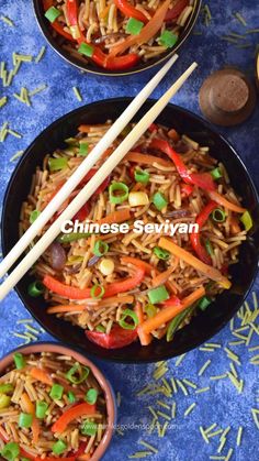 two bowls filled with rice and veggies next to chopsticks on a blue table