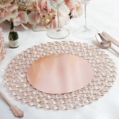 there is a table setting with pink flowers and silverware on the placemats