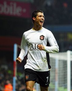 a soccer player is running on the field with his mouth wide open and tongue out