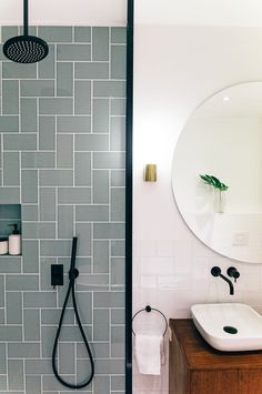 a bathroom with a sink, mirror and shower head on the wall next to it