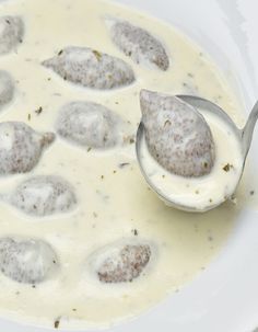 a spoon full of soup with meatballs in it