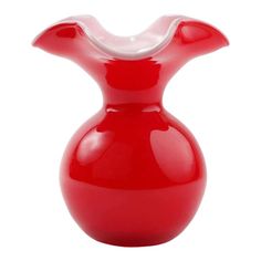 a red vase sitting on top of a white table