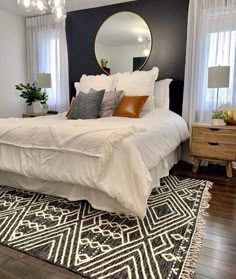 a white bed sitting in a bedroom on top of a wooden floor next to a window