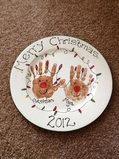 a plate with two handprints on it that says merry christmas and the date 2013