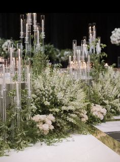 an arrangement of flowers and candles on a table