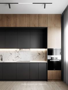 a modern kitchen with black cabinets and marble counter tops, along with wooden flooring