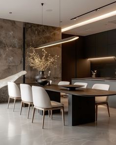 a modern dining room with white chairs and a large table in the middle of it