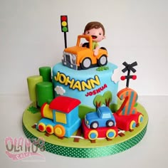 a birthday cake with a boy driving a train on the top and other toys around it