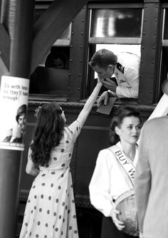 black and white photograph of a woman reaching up to touch the man's hand