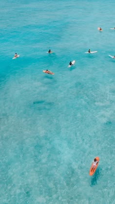 people are swimming in the ocean with surfboards