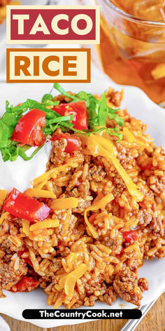 taco rice on a white plate with lettuce and tomatoes in the background