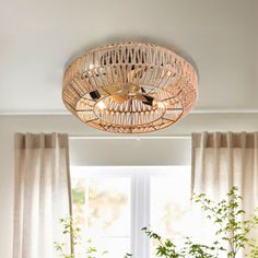 a living room filled with furniture and a light fixture hanging from the ceiling over a table