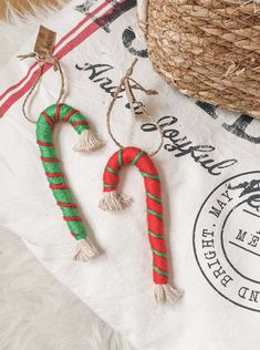 two candy canes are hanging from twine tassels on a white towel