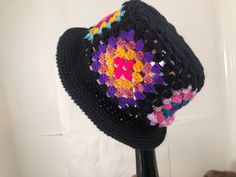 a crocheted hat is on top of a black mannequin headdress