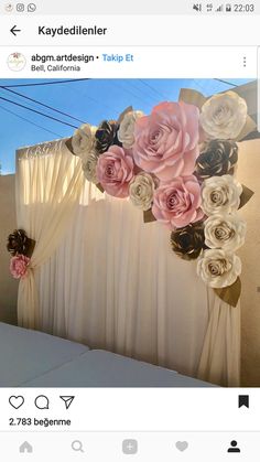 the backdrop is decorated with paper flowers and ribbon tied to it's sides for an elegant touch