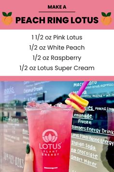 a pink drink sitting on top of a table next to a sign that says peach ring lotus