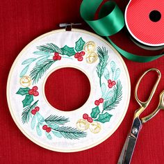 a pair of scissors next to a christmas wreath