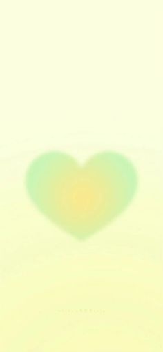 a blurry image of a heart in the middle of a white background with light green and yellow colors