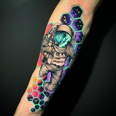 an astronaut tattoo on the right arm and leg, with hexagons in the background