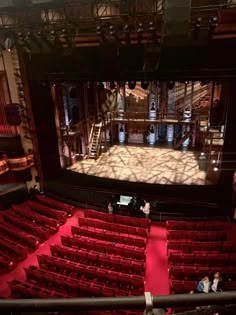 an empty theatre with red seats and people