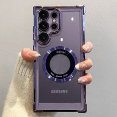 a woman holding up her samsung phone case with the camera lens on it's back