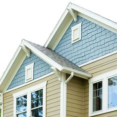 an image of a house that is painted blue and tan with white trim on the windows