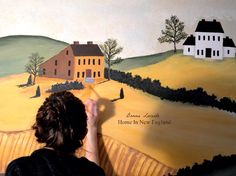 a woman is painting a house on the wall