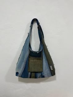 a bag made out of old jeans hanging on a wall with white walls in the background