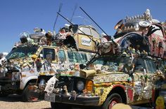 an old van covered in many different items and decorations on top of it's roof