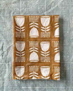 a piece of cloth with white designs on it sitting on top of a blue tablecloth