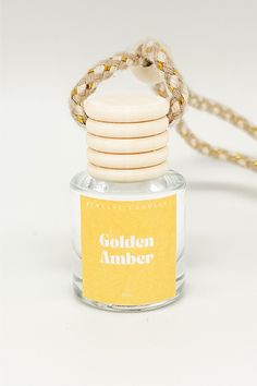 a bottle of golden amber sitting on top of a white table next to a chain