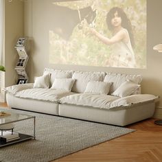 a living room filled with furniture and a large painting on the wall above it's windows