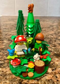 a toy figurine is set up in the shape of a forest with animals and mushrooms