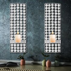 two wall mounted mirrors with candles on them