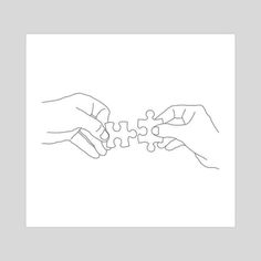 two hands holding pieces of a puzzle together