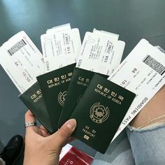 a woman holding five korean passport cards in her hand