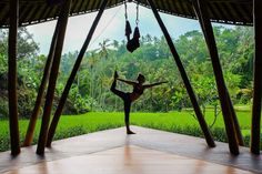 a person doing yoga on a platform in front of some trees