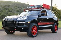 a black suv with red rims parked on the street